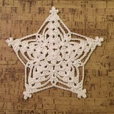 a white crocheted star on top of a wooden table