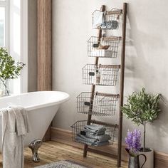 a white bath tub sitting under a window next to a shelf filled with pots and pans