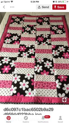 a black and white quilt with pink flowers on it