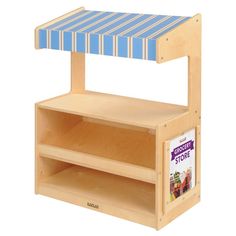 a wooden toy store shelf with blue and white striped awning on it's top