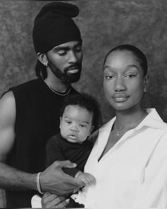 a man and woman holding a baby in their arms