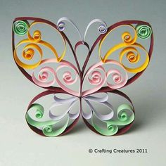 a colorful paper butterfly with swirls on it's wings is shown in this image