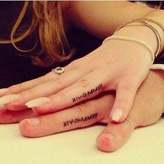 two people with matching tattoos on their hands, one holding the other's hand