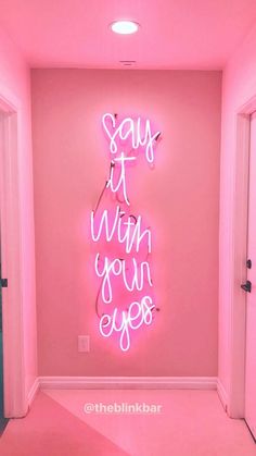 a pink room with neon lights that say it's not worth your eyes on the wall