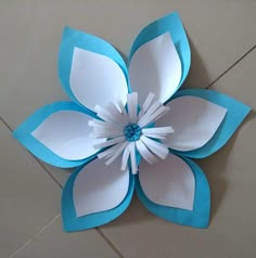 a paper flower made with blue and white paper