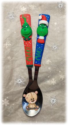 there are two spoons with christmas decorations on them