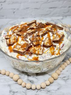 a dessert is in a glass dish on a marble table with wooden beads around it