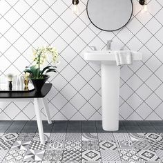 a white sink sitting next to a black and white tiled bathroom floor with a mirror above it