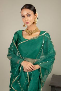 Green saree in organza base with hand embroidered floral buttis. Paired with chanderi blouse. Comes with satin petticoat.
Component: 3
Pattern: Embroidered
Type Of Work: Floral Motifs
Neckline: Round
Sleeve Type: Half Sleeves
Fabric: Saree: Organza; Blouse; Chanderi; Petticoat: Satin
Color: Green
Other Details: 
Sequins work
Back scoop neck blouse
Note: The gold jewellery set worn by the model is for styling purpose only
Occasion: Wedding - Aza Fashions Traditional Organza Pre-draped Saree For Party, Gold Organza Pre-draped Saree For Navratri, Traditional Party Pre-draped Saree In Chanderi, Navratri Celebration Pre-draped Saree With Zari Work, Festive Bollywood Pre-draped Saree In Chanderi, Pre-draped Saree With Dupatta For Diwali Celebration, Eid Celebration Pre-draped Saree, Festive Silk Set With Unstitched Blouse, Festive Chanderi Pre-draped Saree For Celebration