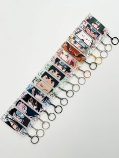 a bunch of key chains with different pictures on them, all hanging from the same length