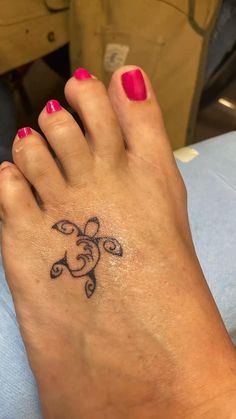 a woman's foot with a small tattoo on it