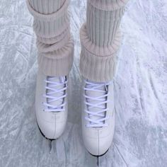 the legs and ankles of a person wearing white shoes with laces on them in the snow