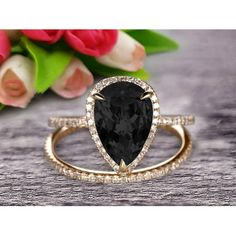 an engagement ring with a pear shaped black diamond