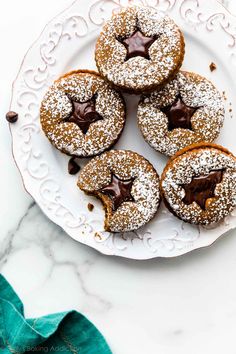 chocolate covered donuts on a plate with powdered sugar