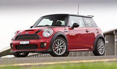 a red mini cooper parked in front of a building