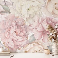 a vase with flowers sitting on top of a white table next to a wallpaper