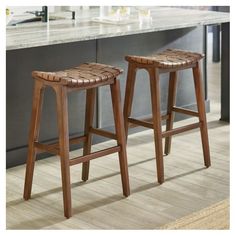 two wooden stools sitting on top of a kitchen counter