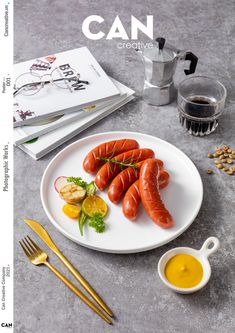 a plate with four cooked sausages on it next to a cup of tea and goldware