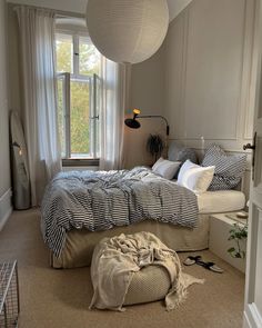 a bedroom with a large bed and two windows