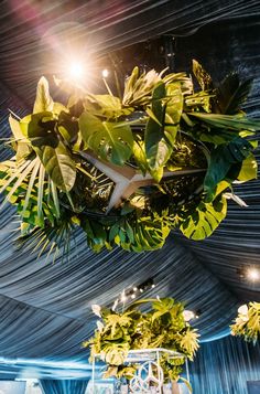 the ceiling is decorated with greenery and lights