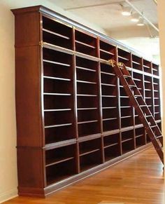 a ladder leaning against a bookcase in an empty room