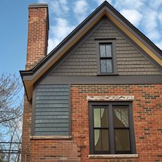 a brick house with two windows and a chimney