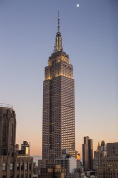 the empire state building in new york city, ny is lit up at night with text reading visit the empire state build