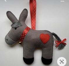 a stuffed donkey ornament with a red heart on it's nose and tail