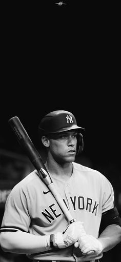 a black and white photo of a new york yankees baseball player holding a bat in his hands