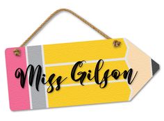 a yellow and pink sign with the word miss gibson hanging from a string on a white wall