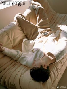 a woman laying on top of a bed covered in sheets and pillows with her eyes closed