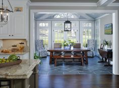 a dining room table and chairs in a kitchen with blue tile on the flooring