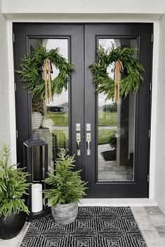 two potted plants are sitting on the front porch with black and white rugs