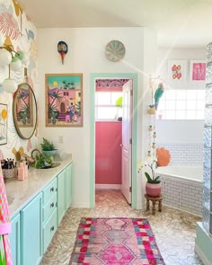 a bathroom with a pink door and green cabinets in the corner, along with pictures on the wall