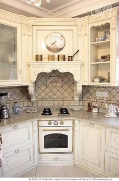 a kitchen with white cabinets and a clock on the wall above the stove top oven