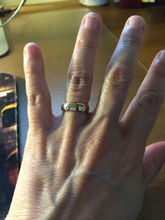 a person's hand with a ring on it