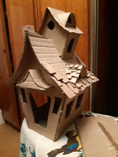 a cardboard house sitting on top of a table