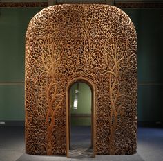 an intricately carved wooden door in the middle of a room