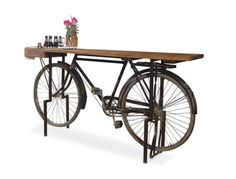 an old fashioned bicycle table with flowers and bottles on the back wheel, against a white background