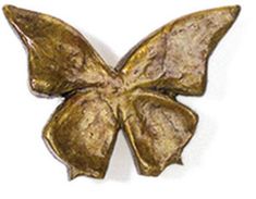 a gold colored metal butterfly on a white background