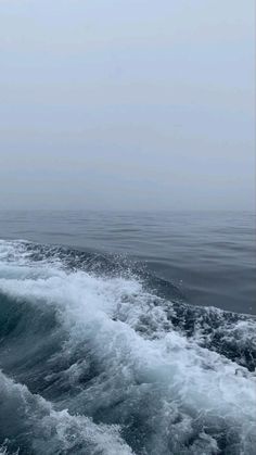 the wake of a boat in the ocean on a foggy day