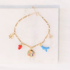 With this whimsical bracelet, you can add a pop of color and a little good fortune to your life! We've hand-picked five cheeky charms to bring you good luck and a smile every time you wear this unique gold-plated bracelet on your wrist: flower, strawberry, good luck, blue coral, and a bumblebee—this 7-inch bracelet comes with a 1 inch extender. Mother Child Necklace, Violet Necklace, Custom Charm Bracelet, Morse Code Necklace, Lucky Charm Bracelet, Love Knot Ring, Single Stone Ring, Floating Necklace, Thread Earrings