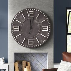 a large clock mounted to the side of a wall above a fire place in a living room