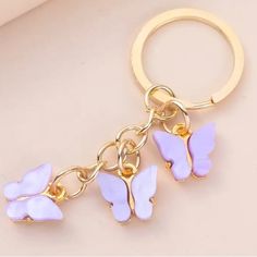 a key chain with three purple butterflies on it