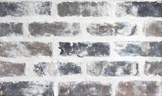 an old brick wall that has been painted gray and white