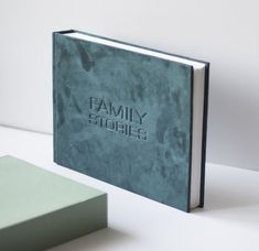 a blue book sitting on top of a white table next to a green square box