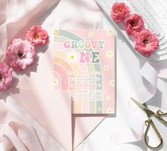 there is a card with flowers on it next to some scissors and pink paper towels