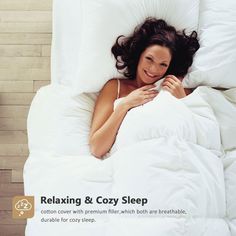 a woman laying in bed with white sheets and pillows