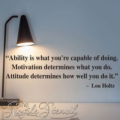 a wall mounted lamp next to a quote on the wall that says ability is what you're capable of doing motivation determines what you do