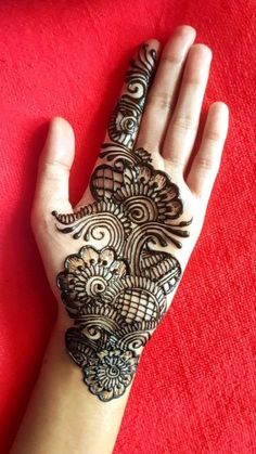 a woman's hand with henna tattoos on it